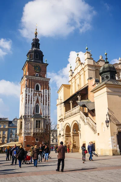 KRAKOW, POLAND - March 07 2015: Tourists enjoying an spring day in The Grand Central Square in front of the The Renaissance Sukiennice also known as The Cloth Hall, Krakow, Poland March 07 2015 — Stock Photo, Image