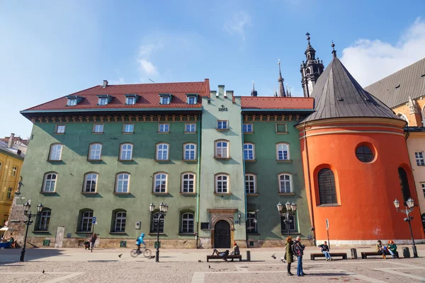 KRAKOW, POLONIA - 07 de marzo de 2015: Turistas no identificados visitan la pequeña plaza del mercado en Cracovia, Polonia, el 07 de marzo de 2015. Casco antiguo de Cracovia declarado patrimonio de la Unesco —  Fotos de Stock