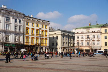 KRAKOW, POLAND - March 07 2015: Unidentified tourists visiting main market square in Krakow, Poland on March 07 2015. Old town of Cracow listed as unesco heritage site