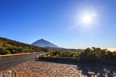 Üzerinde mavi gökyüzü dağlardaki güneş ışığı ile güneşle sis ve Teide yanardağı, Tenerife, Kanarya Adaları, İspanya