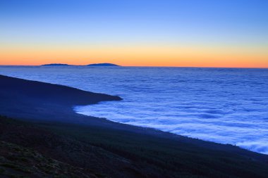 Bulutların üzerinde son güneş ışığı, Tenerife, Kanarya Adaları, İspanya ile okyanus su üzerinde havadan görünümü