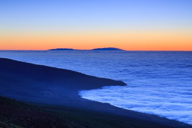 Bulutların üzerinde son güneş ışığı, Tenerife, Kanarya Adaları, İspanya ile okyanus su üzerinde havadan görünümü