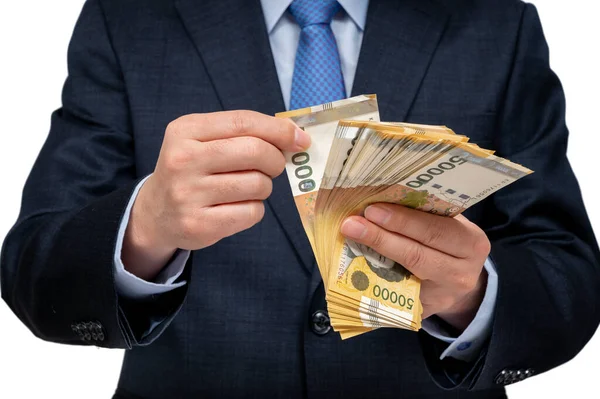 Geschäftsmann hält koreanische Währung auf weißem Hintergrund in der Hand. — Stockbild Geschäftsmann hält koreanische Währung auf weißem Hintergrund in der Hand. — Stockfoto