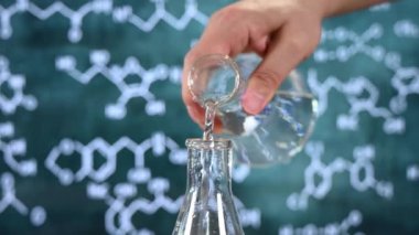 Tahta arka planı ve çeşitli kimyasal formülleri olan laboratuvar camları..