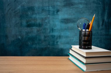 Kitaplar masanın üstünde ve boş bir tahta. Eğitim kavramı.