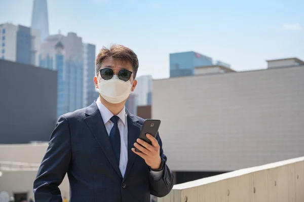 Asiatisk Mandlig Forretningsmand Holder Smartphone Iført Solbriller Maske Byen - Stock-foto