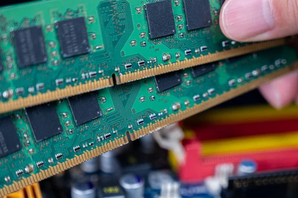 Hand with memory on a computer motherboard. — Stock Photo, Image