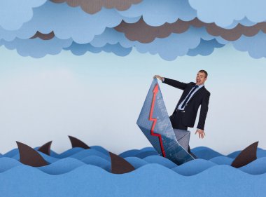 Businessman and paper boat is sinking into paper sea. clipart