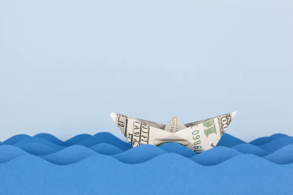 Dollar boat swimming on paper waves — Stock Photo, Image