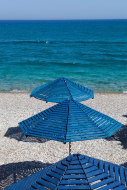 Bir plajda, Rhodes mavi şemsiye