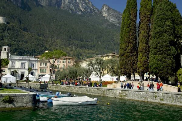 Ihmiset kävelevät pitkin Garda järven reunaa Riva del Garda kaupungissa, Italiassa — kuvapankkivalokuva