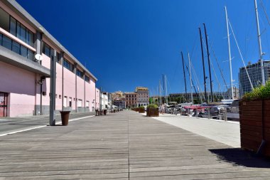 CAGLIARI, ITALY, AĞUSTOS 15, 2019, Cagliari Marina 'daki tahta yol manzarası. Via Roma, Sardinya, İtalya 'nın arka planında zarif ve tarihi binalar bulunuyor..