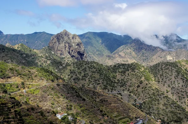 La Gomera - Roque El Cano sobre a cidade de Vallehermoso. No fundo o nublado Cumbre de Chijere com Buenavista . — Fotografia de Stock