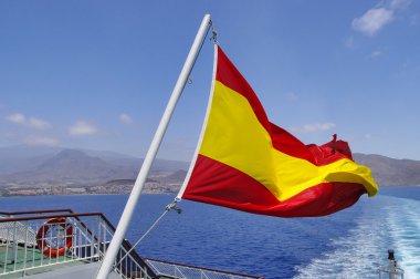 Rüzgarda dalgalı bir direk üzerinde İspanyol bayrağı 