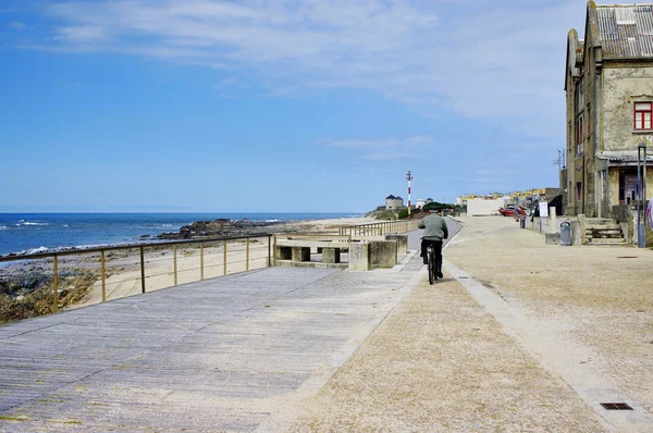 Senior drev en cykel på promenaden utmed stranden Apulien i Esposende, Portugal. Apulien beach är en del av Parque Natural Litoral i norra Portugal. — Stockfoto