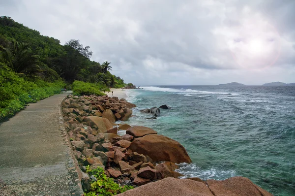 Marea baja en la salvaje costa este de La Digue, Seychelles con la única carretera en primer plano — Foto de Stock