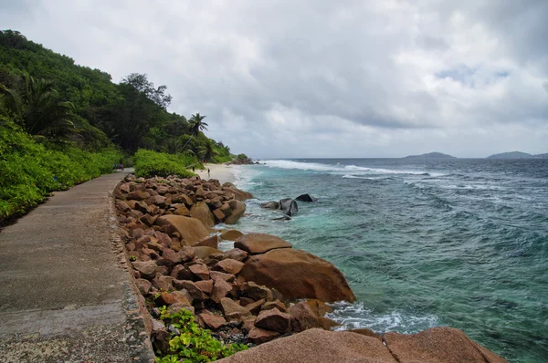 Marea baja en la salvaje costa este de La Digue, Seychelles con la única carretera en primer plano — Foto de Stock