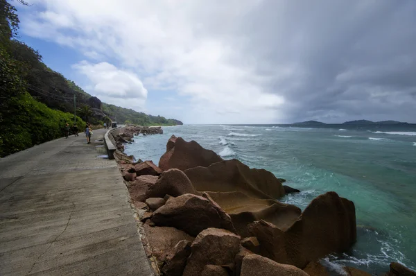 Низкий прилив на восточном побережье Ла-Диг, Сейшельские Острова с единственной дорогой на переднем плане — стоковое фото