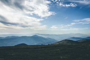 Rüzgarlı bir günde Gökyüzü ile mavi. Sis içindeki uzak dağlar. Gizemli manzara. 