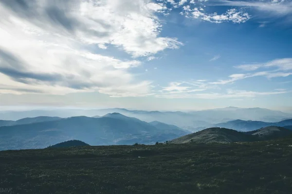 Rüzgarlı bir günde Gökyüzü ile mavi. Sis içindeki uzak dağlar. Gizemli manzara. 