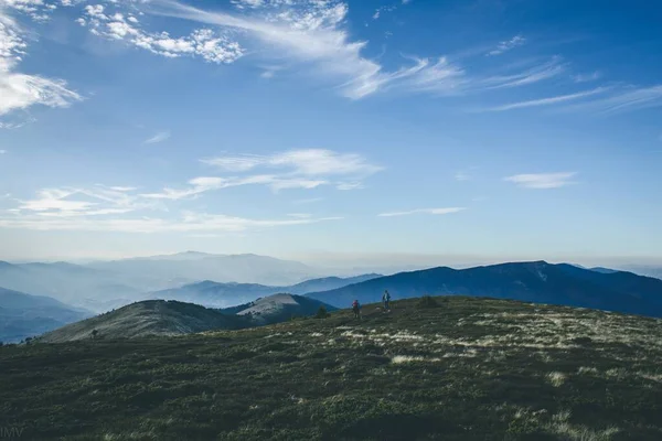 Dağ takibi Mavi gökyüzü arkaplanındaki insanlar. Soğuk tonlarda mevsimlik fotoğraf