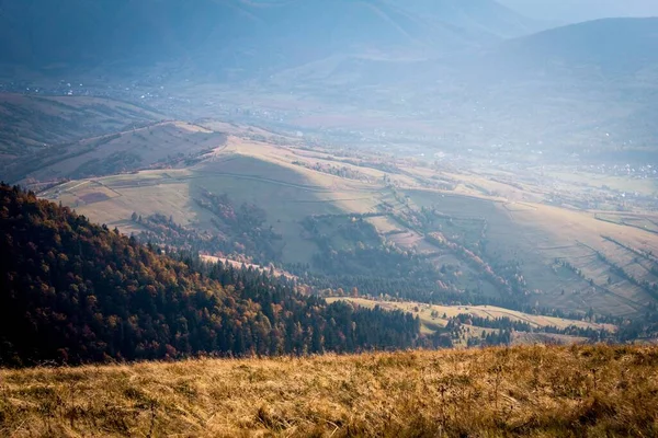 Dağ manzarası. Tepeden vadideki bir köye bak. Fotoğraf sonbahar altın renginde, sisli..