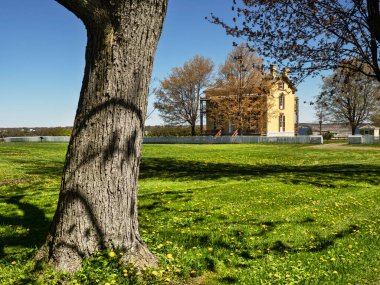 Sackets Harbor, New York, ABD. 12 Mayıs 2021. Sackets Limanı Savaş Alanında, arka planda Donanma Komutanı 'nın Evi olan bir ağaç.