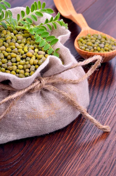 Mungbohnen im Sack auf hölzernem Hintergrund. — Stockfoto