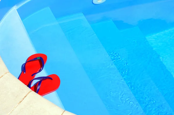 Chanclas en contra de fondo de agua azul . —  Fotos de Stock