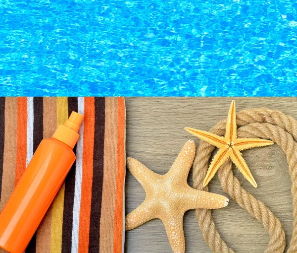 Starfish, color towel and sunscreen spray against. — Stock Photo, Image