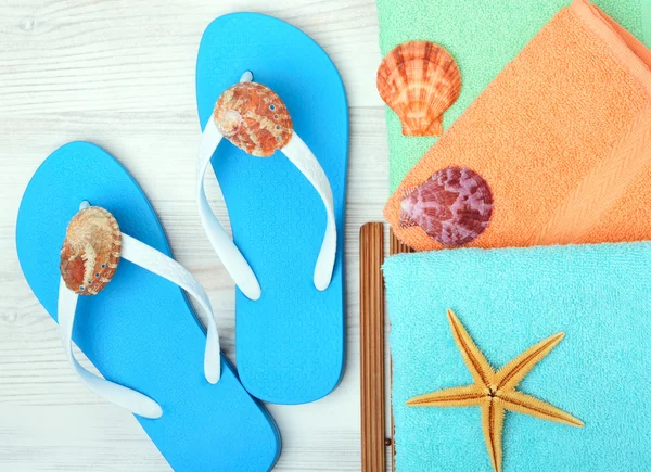 Flipflops, Handtuch, Seesterne und Muscheln. — Stockfoto