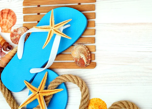 Flipflops, Seesterne und Muscheln. — Stockfoto