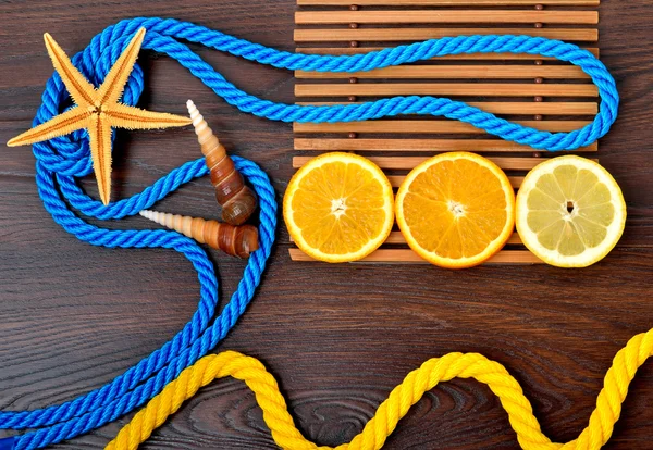 Frutas exóticas. Conchas y cuerda sobre fondo de madera . —  Fotos de Stock