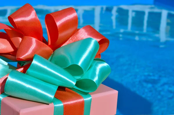 Gift box against the background of the pool. — Stock Photo, Image