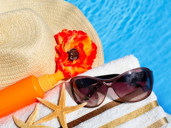 Bonnet de plage, lunettes de soleil, serviette de bain, spray solaire, étoile de mer . — Photo