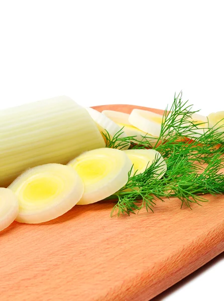 Fresh sliced leeks and dill on a wooden board — Stock Photo, Image