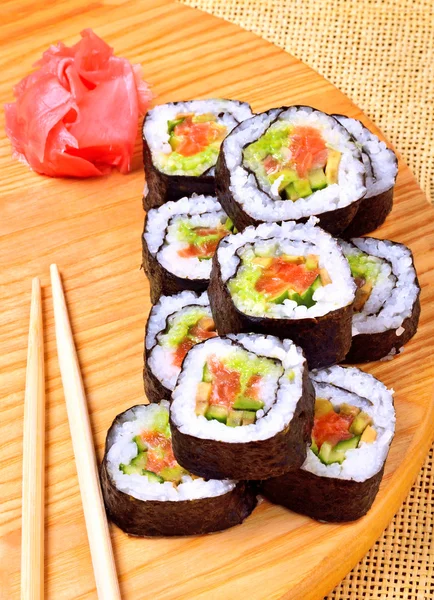 Sushi, Rollen, Ingwer und Essstäbchen auf Bambusmatte — Stockfoto