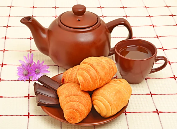 Tetera marrón, taza y salchicha con croissant — Foto de Stock