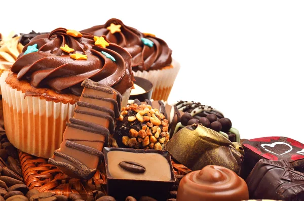 Muffin al cioccolato con un mucchio di dolci al cioccolato, caramelle isola Immagine Stock