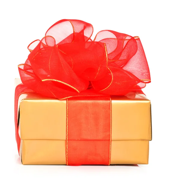 Gouden geschenkdozen met een rode strik — Stockfoto