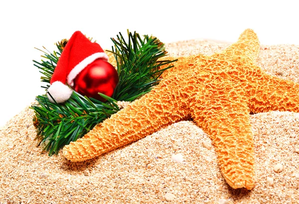 海星、 圣诞挂件和松树枝在沙滩上 — 图库照片
