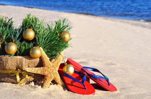Christmas tree with christmas balls, slippers and starfish on th — Stock Photo, Image