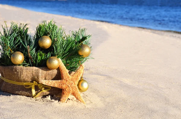 Kerstboom met gouden kerstballen en zeester op de s — Stockfoto