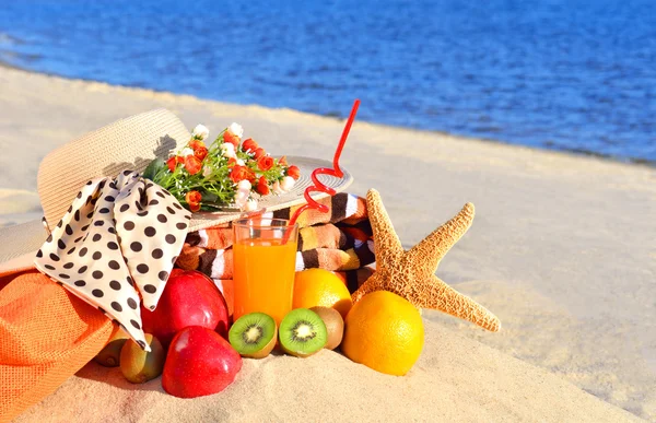 Chapéu de mulher, frutas diferentes, estrela do mar e copo de suco no — Fotografia de Stock