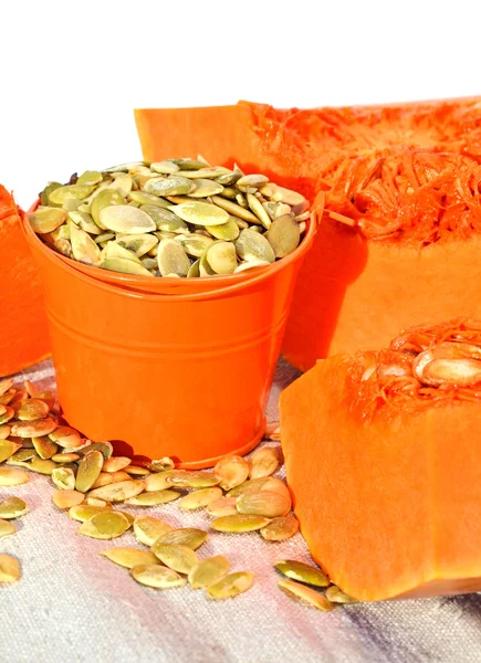 Calabaza madura con semillas de calabaza en el cubo naranja — Foto de Stock
