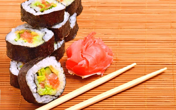 Sushi, rouleaux, gingembre et baguette sur tapis de bambou — Photo