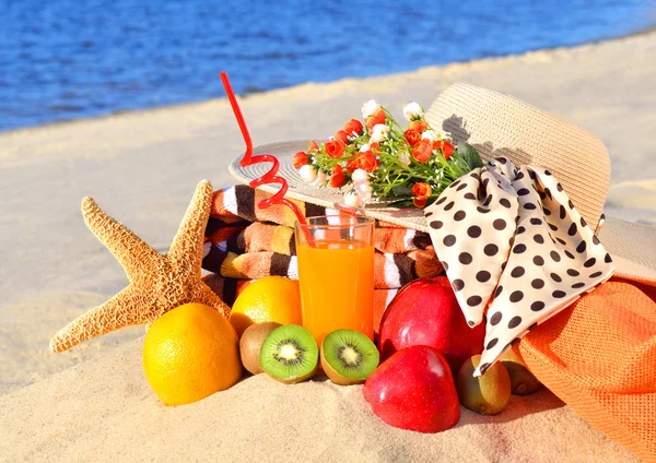 Chapéu de mulher, frutas diferentes, estrela do mar e copo de suco no — Fotografia de Stock