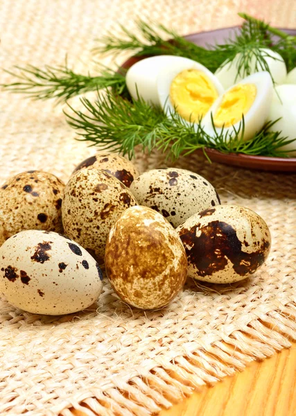 Heap de ovos de codorna crua no saque e ovos de codorna cozidos em t — Fotografia de Stock