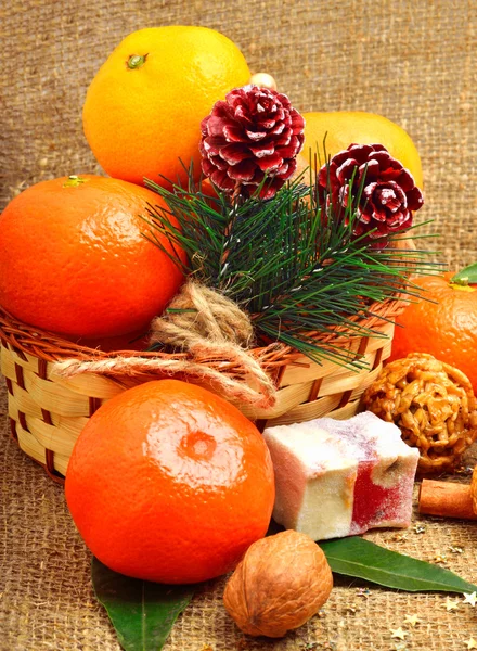 Christmas tangerines with sweet delights, walnuts, pinecone and — Stock Photo, Image