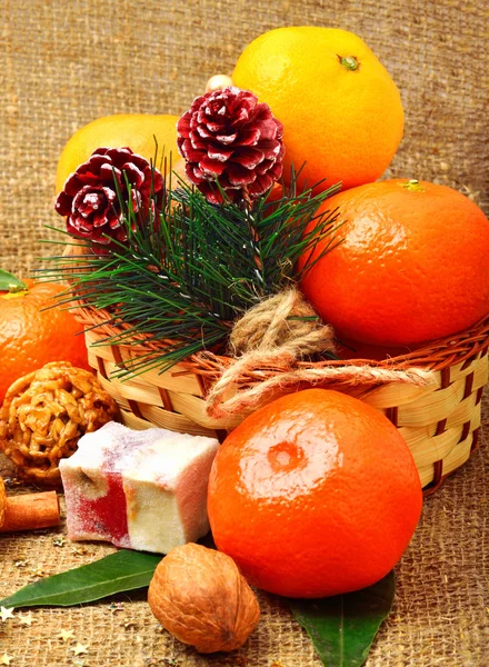 Mandarinas de Navidad con delicias dulces, nueces, conos de pino y — Foto de Stock